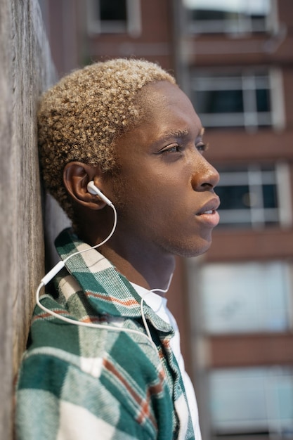 Portrait en gros plan d'un homme afro-américain triste écoutant de la musique regardant loin dans la rue