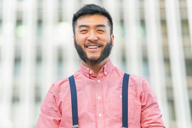 Portrait en gros plan d'un homme asiatique souriant à l'extérieur