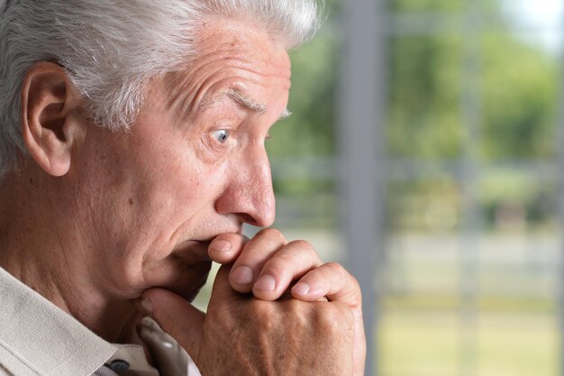 Portrait en gros plan d'un homme senior triste à la maison