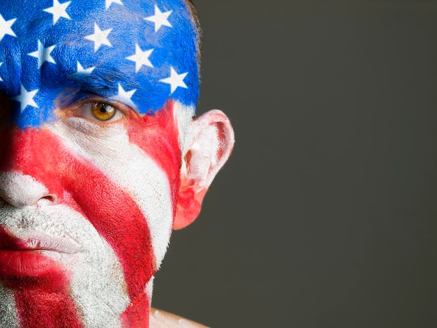 Photo portrait en gros plan d'un homme triste avec la peinture du corps du drapeau américain sur un fond gris