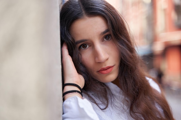 Portrait en gros plan d'une jeune femme caucasienne aux cheveux longs regardant la caméra