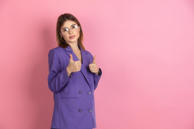 Portrait en gros plan d'une jeune femme caucasienne sur fond de studio rose, émotionnel et expressif