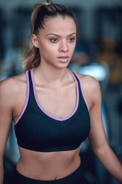 Portrait en gros plan d'une jeune femme confiante dans la salle de sport