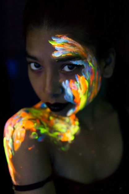 Portrait en gros plan d'une jeune femme avec de la peinture sur le visage et l'épaule