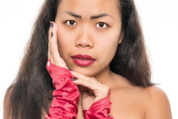 Photo portrait en gros plan d'une jeune femme portant du rouge à lèvres sur un fond blanc