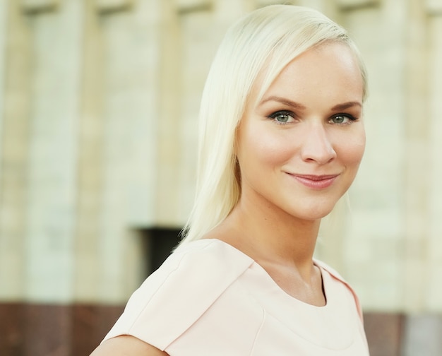 Portrait en gros plan d'une jeune femme riant et posant dans le contexte de la ville