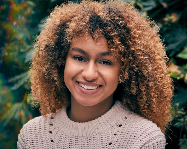 Portrait en gros plan d'une jeune femme souriante aux cheveux bouclés
