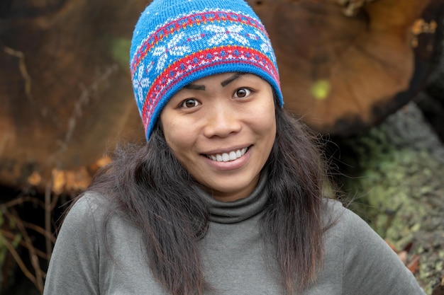 Portrait en gros plan d'une jeune femme souriante debout à l'extérieur