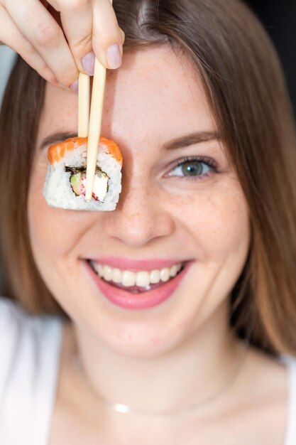 Portrait en gros plan d'une jeune femme avec des sushis