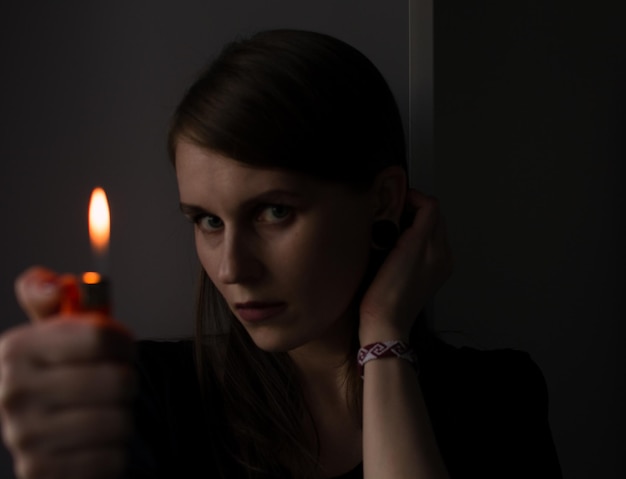 Portrait en gros plan d'une jeune femme tenant un allumeur
