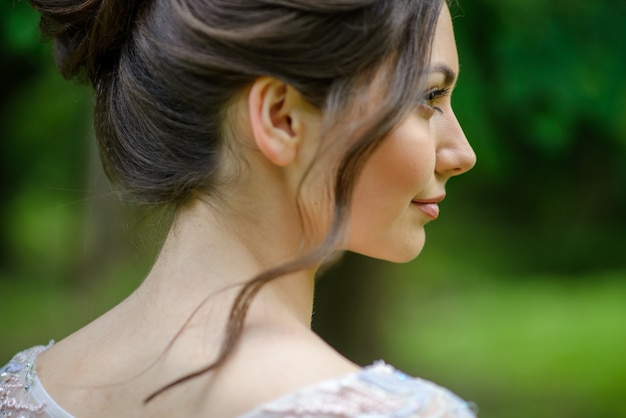 Portrait de gros plan d'une jeune fille. La fille se tient de côté. La boucle d'une femme tombe.