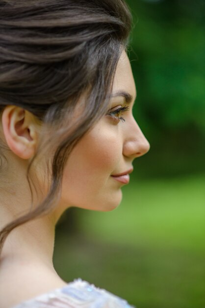 Portrait de gros plan d'une jeune fille. La fille se tient de côté. La boucle d'une femme tombe.