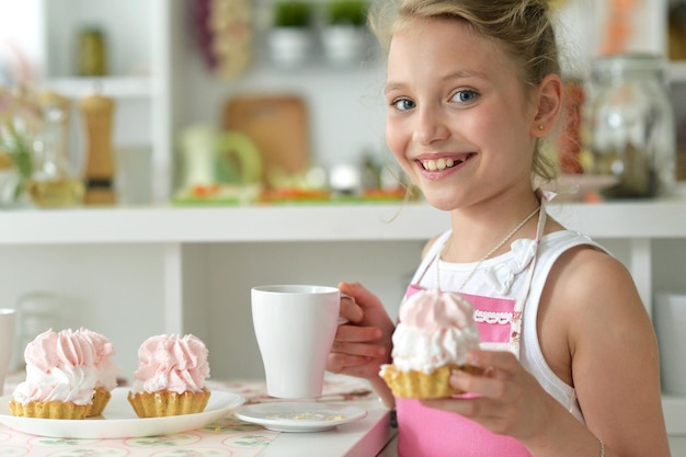 Portrait en gros plan d'une jeune fille mangeant des cupcakes
