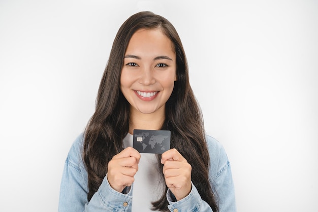Portrait en gros plan d'une jeune fille montrant une carte de crédit isolée sur fond blanc