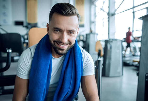 Portrait en gros plan d'un jeune homme sportif dans la salle de sport