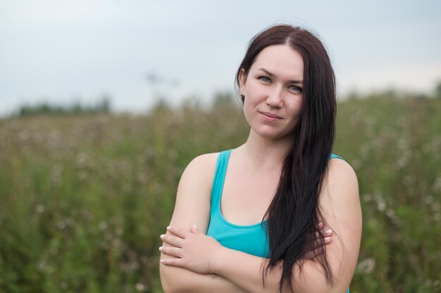 Portrait en gros plan d'une jolie femme brune sur un champ floral d'automne