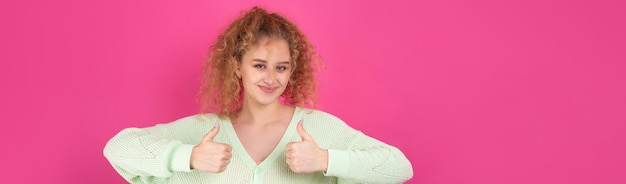 Photo portrait en gros plan d'une jolie fille surprise montrant le geste du pouce levé concept de chance de succès