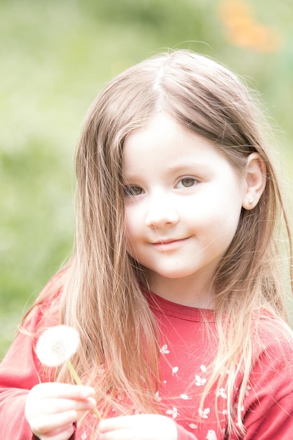 Portrait en gros plan d'une jolie fille tenant une fleur