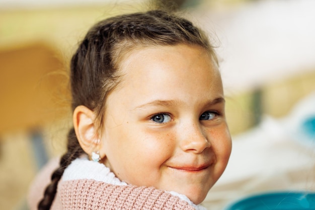 Portrait en gros plan d'une jolie petite fille souriante aux beaux yeux bleus Vacances d'été dans le centre touristique du camp Se détendre et jouer à des activités sportives en salle et à des loisirs de mode de vie sain