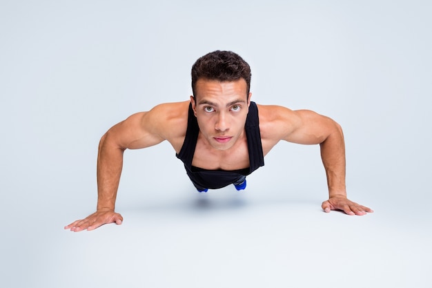 Portrait en gros plan d'un mec macho sportif fort faisant des pompes entraînement à la motivation