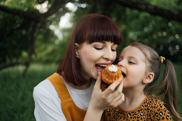 Portrait en gros plan d'une mère célibataire avec une petite fille qui mange du gâteau