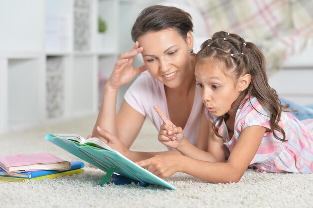 Portrait en gros plan d'une mère avec sa fille faisant ses devoirs