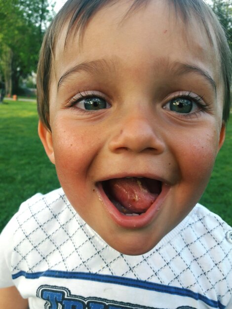 Photo portrait en gros plan d'un mignon garçon à la bouche ouverte debout à la maison