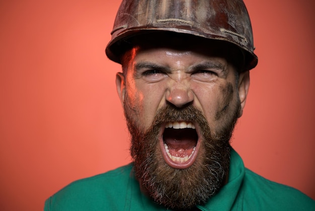 Photo portrait en gros plan d'un ouvrier de la construction criant dans un chapeau de sécurité, d'un constructeur en colère dans un casque de sécurité criant