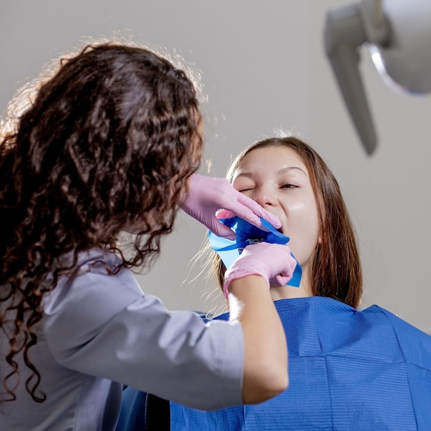 Portrait en gros plan d'une patiente visitant un dentiste pour un blanchiment des dents en clinique.