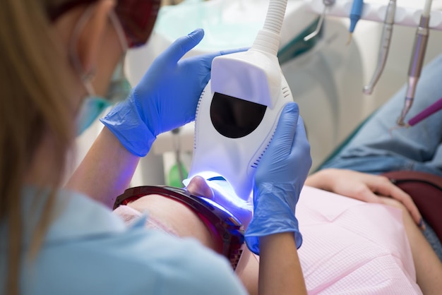 Portrait en gros plan d'une patiente visitant un dentiste pour le blanchiment des dents dans une clinique montrant qu'il...