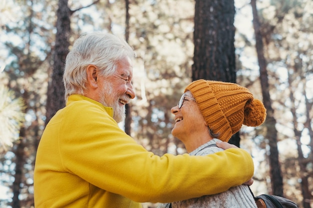 Portrait en gros plan de personnes âgées souriantes et appréciant de se regarder dans la forêt de montagne