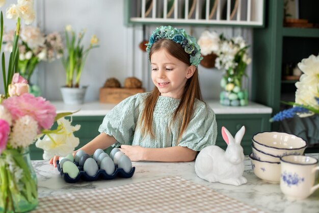 Portrait en gros plan d'une petite fille heureuse avec un bouquet de fleurs dans la cuisine de Pâques