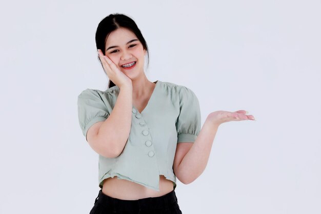 Portrait en gros plan tourné en studio d'une jeune adolescente asiatique portant une tenue décontractée debout pose une action publicitaire sur fond blanc.