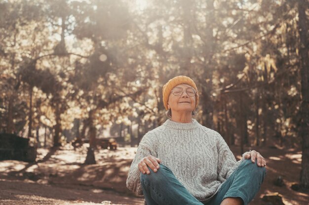 Photo portrait en gros plan d'une vieille femme d'âge moyen se reposant et se relaxant en faisant du yoga dans les forêts