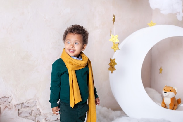 Portrait de gros plan d'un visage de garçon noir, petit garçon afro-américain. petit garçon noir sourit. Bébé mignon, bébé dans le jeu. Joli sourire. Cheveux bouclés. Mulat. Aventures du petit prince au mois.