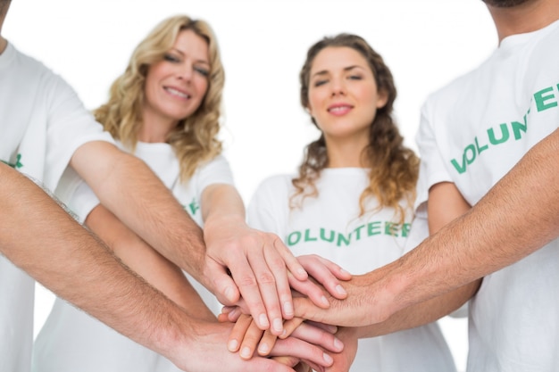 Portrait de groupe de bénévoles heureux avec les mains ensemble