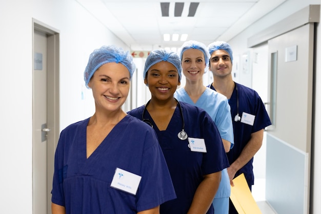 Photo portrait d'un groupe diversifié de travailleurs de la santé portant des casquettes chirurgicales souriant dans le couloir de l'hôpital. services hospitaliers, médicaux et de santé.