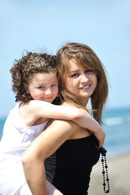 portrait de groupe d'enfants heureux avec une jeune enseignante sur la plage