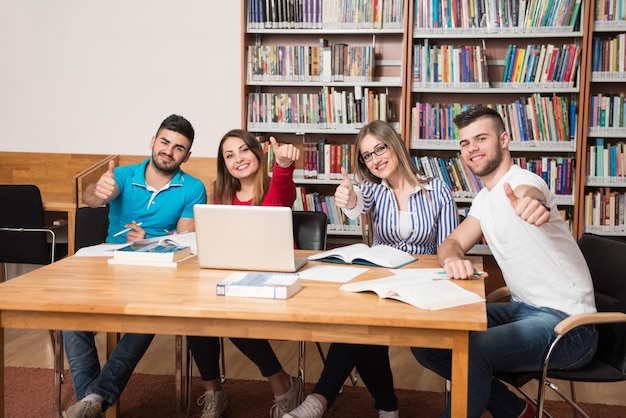 Portrait d'un groupe d'étudiants Showing Thumbs Up in College Library faible profondeur de champ