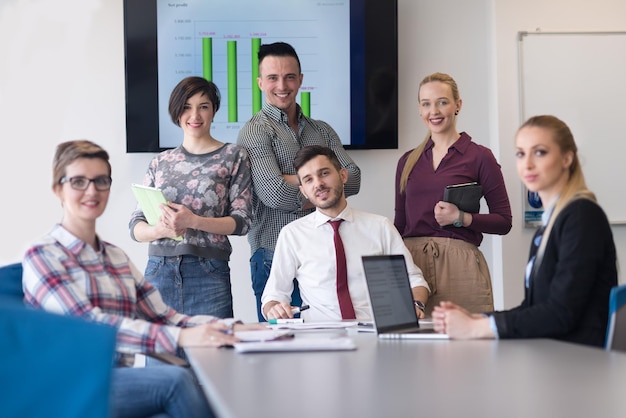 portrait d'un groupe de gens d'affaires dans la salle de réunion moderne et lumineuse du bureau de démarrage, jeune homme avec barbe assis au milieu en tant que chef d'équipe