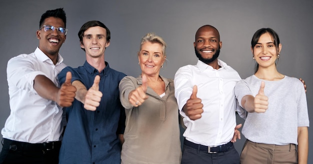 Portrait de groupe d'hommes d'affaires et pouces vers le haut par le mur avec le sourire de travail d'équipe ou la diversité à l'agence d'assurance