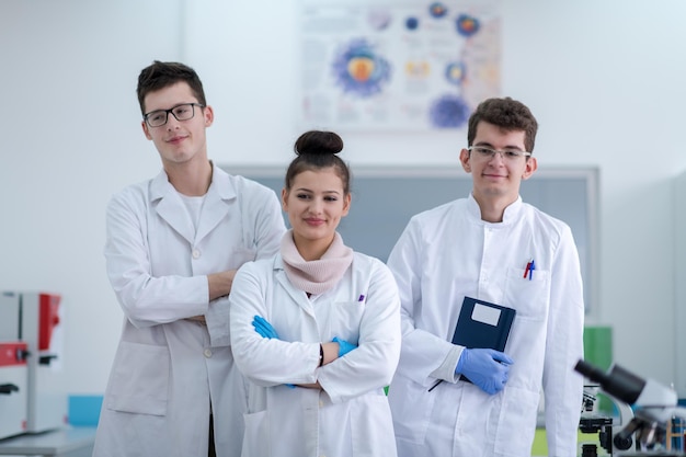 portrait d'un groupe de jeunes étudiants en médecine debout ensemble dans un laboratoire de chimie, travail d'équipe par un étudiant à l'intérieur