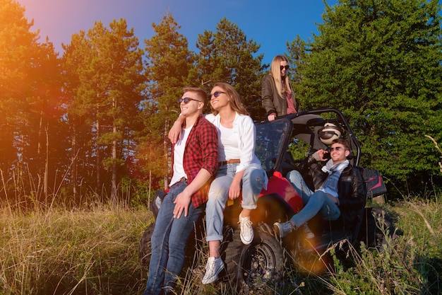 portrait d'un groupe de jeunes gens heureux profitant d'une belle journée ensoleillée tout en conduisant une voiture buggy hors route sur la nature de la montagne