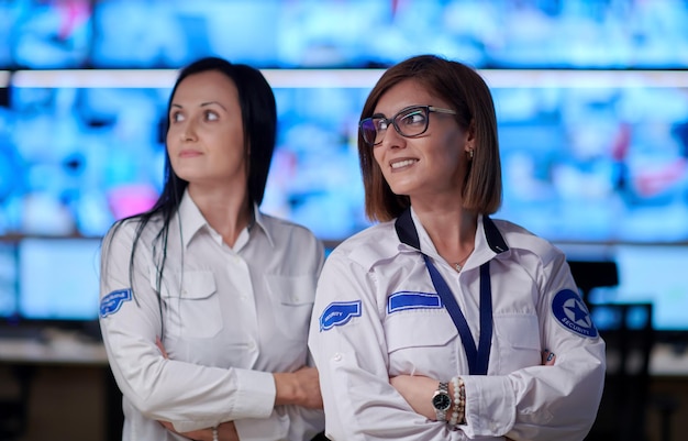 portrait de groupe d'une opératrice de sécurité travaillant dans des bureaux de salle de contrôle d'un système de données Opérateur technique travaillant au poste de travail avec plusieurs écrans, agent de sécurité travaillant sur plusieurs mon