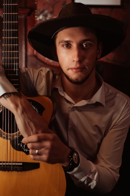 Portrait d'un guitariste masculin assis avec une guitare