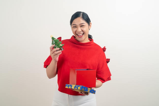 Portrait happy Asian woman wearing red shirt avec boîte-cadeau à portée de main pour le festival de Noël