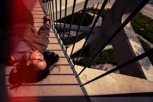 Photo portrait en haut angle d'une femme se détendant sur une balustrade