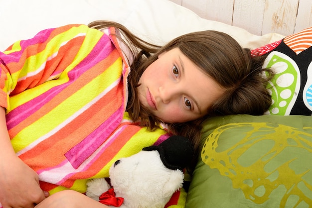 Portrait en haut angle d'une fille se détendant sur le lit à la maison