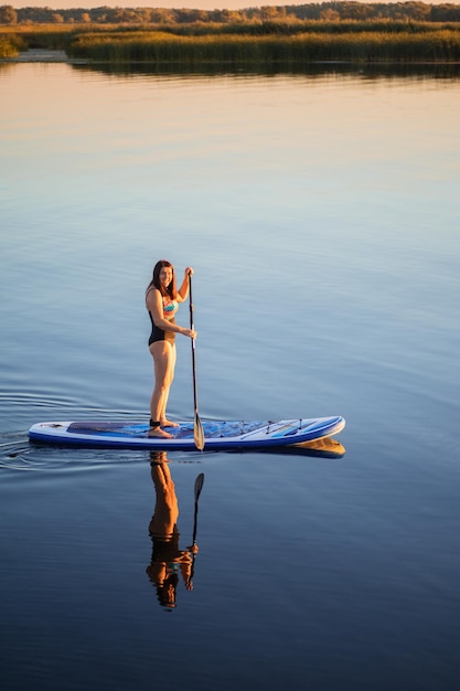 Portrait d'en haut d'une femme caucasienne d'âge moyen sup embarquement sur le lac en soirée en été à la recherche