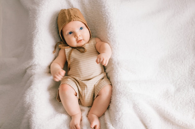 Portrait d'en haut de joli petit bébé en pyjama élégant allongé sur le lit